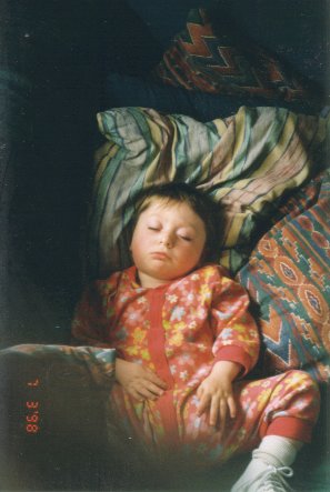 My daughter sleeping peacefully on cushions at home.
