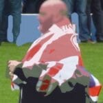 Post-production image of a bald man with a union jack or flag or whatever you call it over his shoulders
