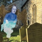A medieval angel figure floats over a gravestone in a sunny graveyard.