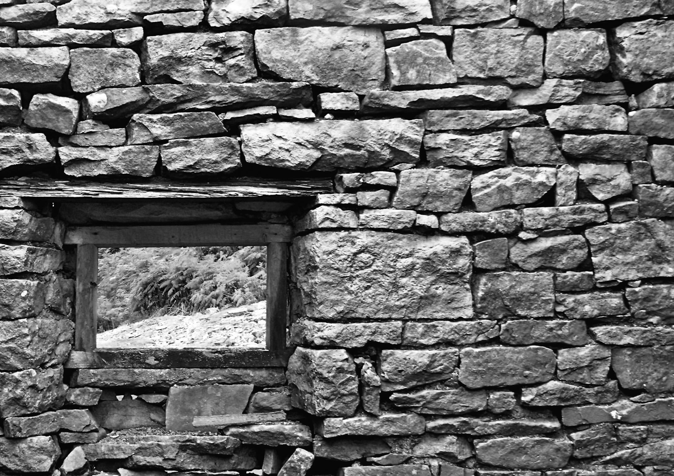 A drystone wall with a window looking in.