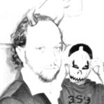 A black and white image of a smartly man in a beard. He has horns sticking out of his head. A boy dressed as a demon is behind him.