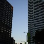 Two tower blocks left and right split by a blue evening sky.