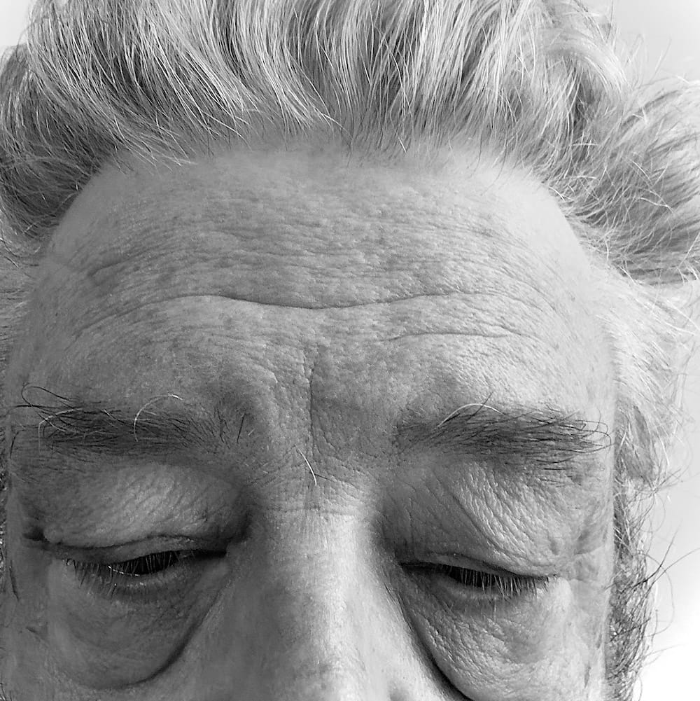 A grey haired with huge bags under his eyes.