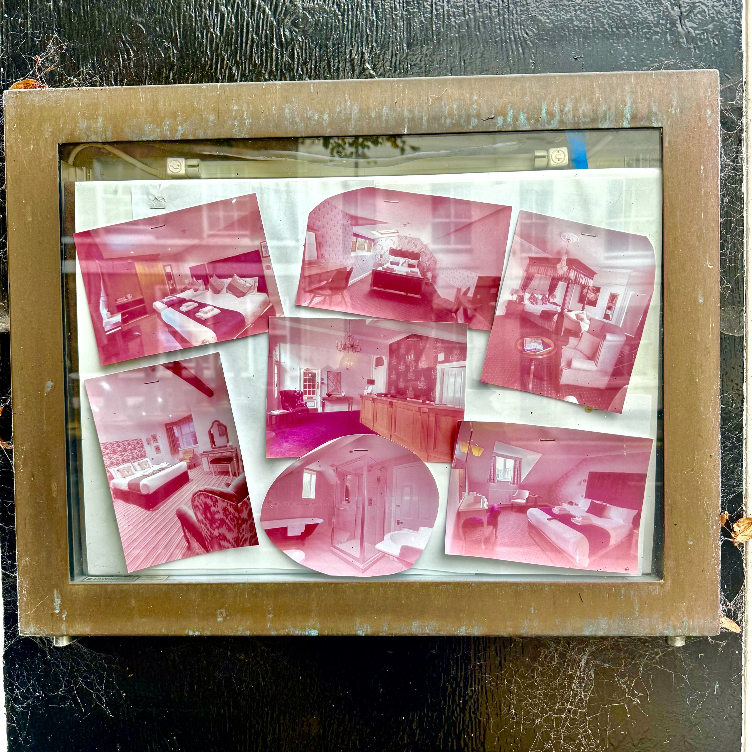 Faded red images are framed against a black wall.